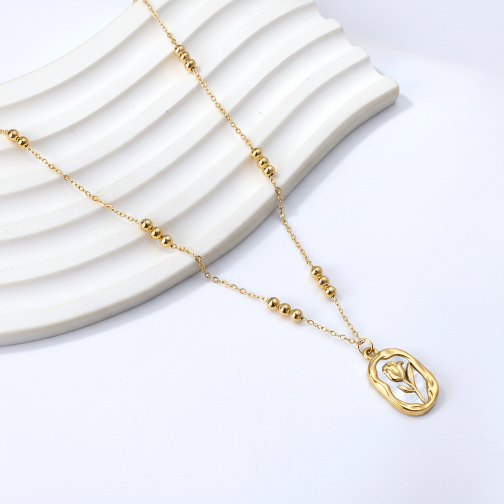 Tulip pendant beaded chain necklace on white ribbed ceramic tray